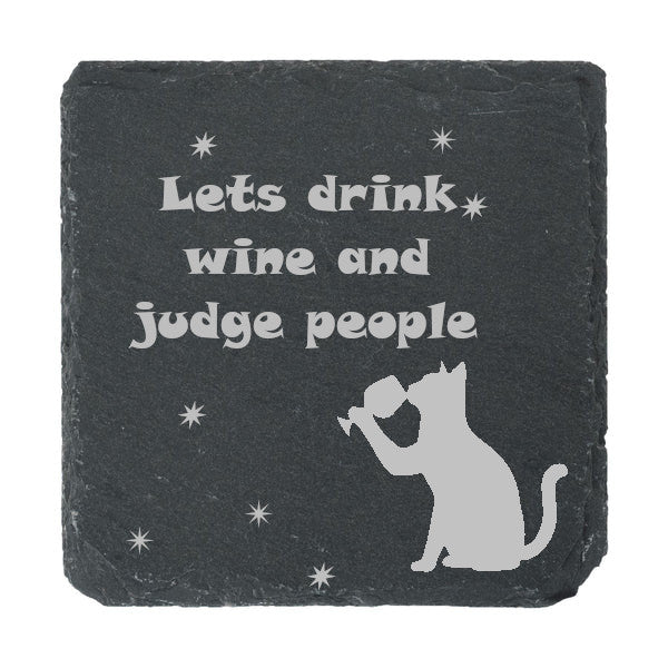 A slate coaster etched with "Lets drink wine and judge people" 
