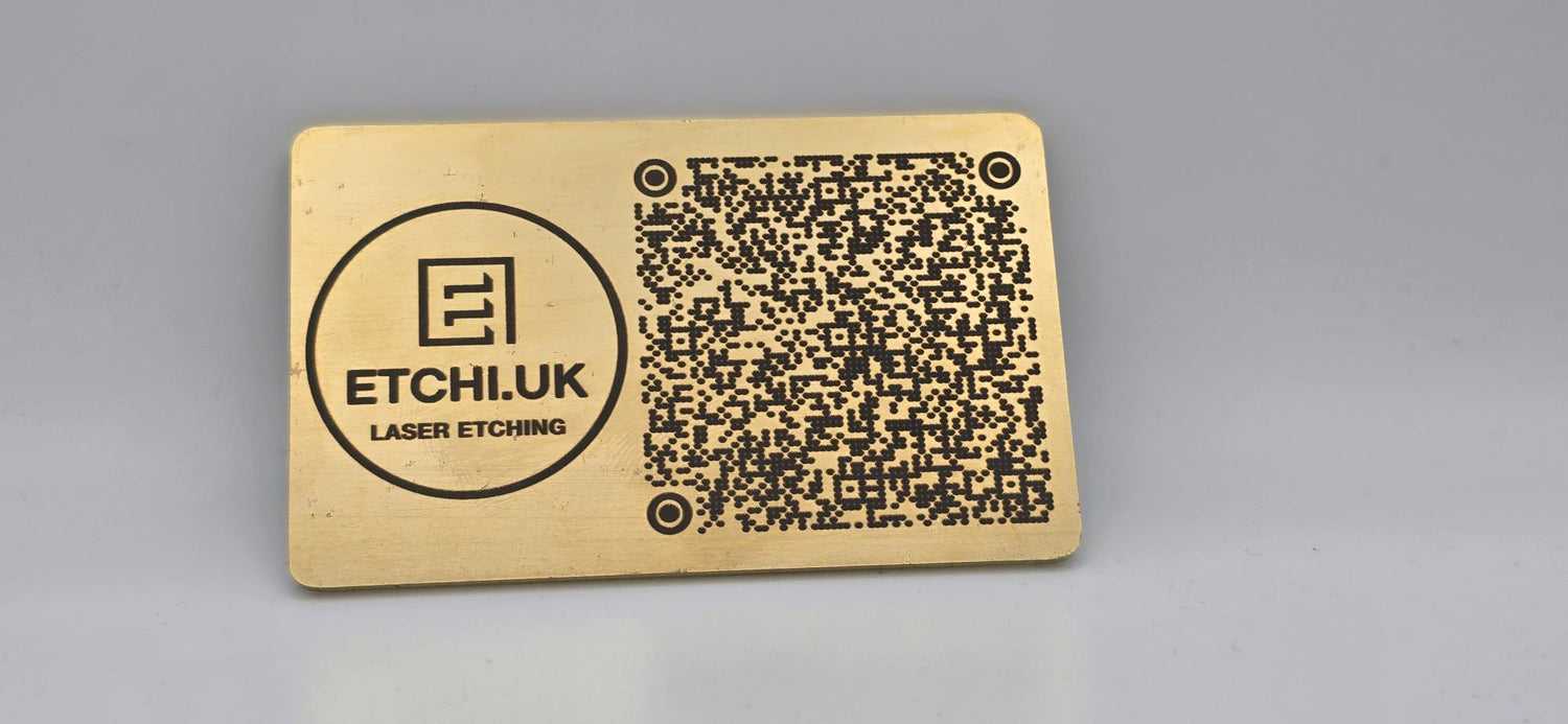 Gold metal card with laser engraved QR code and branding on a gray background