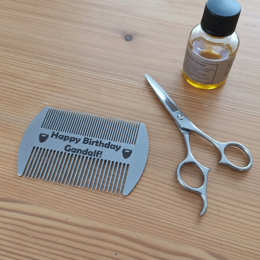 Metallic comb with 'Happy Birthday Gandalf!' text on a wooden surface