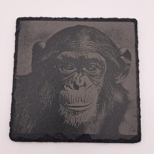 A beautifully etched slate coaster featuring a cute chimpanzee